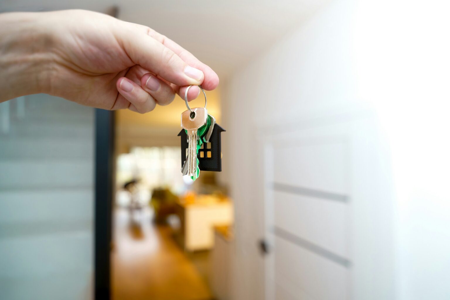 Hands holding house keys at the front door of a rental home